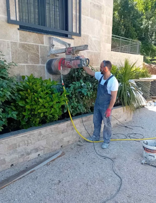 Radnik firme Zoronjić Company buši otvor u spoljašnjem zidu